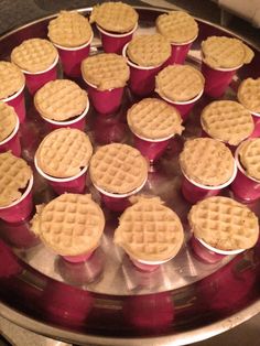 many waffles are placed on top of each other in red cups and pink lids