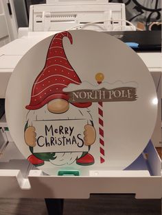 a plate with a santa clause on it sitting in front of a computer keyboard and printer