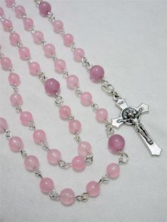 This pink First Communion rosary for girls is made with 6mm pale pink agate rounds and 8mm matte pink cat's eye beads. It measures about 27 inches around the body and has a 5 inch cross drop. The crucifix and the chalice are Italian made oxidized silver. I hand turned the silver plated wires. This rosary will be slipped into a velvet bag and shipped in a bubble mailer. Pink Rosary With 8mm Round Beads, Pink 8mm Beads Crucifix Jewelry, Catholic Communion, Catholic Rosary, Matte Pink, Rosary Catholic, Pink Agate, Eye Beads, Bubble Mailer