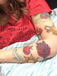 a woman with tattoos on her arm laying in bed