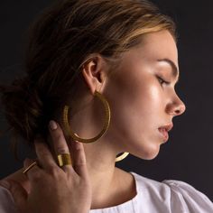 Turn heads with our bold Ridge Hoop Earrings. Handcrafted with brass, their flamenco-inspired shape makes a dramatic (yet lightweight) statement. While our designs are modern, our approach is based in capturing the ancient. We collaborate with master craftspeople to create each piece. Finish: Brass Diameter: Approximately 2.75 inches Made entirely by hand, slight variations make each piece truly one of a kind Handcrafted in Nepal Luxury Brass Hoop Earrings As Statement Piece, Modern Polished Brass Hoop Earrings, Luxury Brass Dangle Hoop Earrings, Luxury Brass Hoop Earrings, Chic Gold-tone Brass Hoop Earrings, Brass Earrings, Statement Earrings, Sterling Silver Earrings, Hoop Earrings