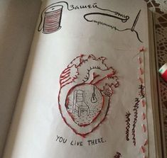 an open book with drawings and writing on the pages, including a drawing of a heart