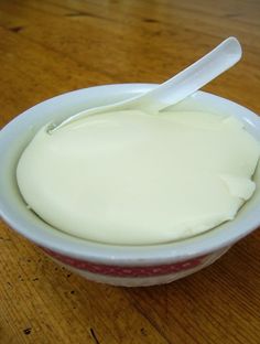 a white bowl filled with yogurt on top of a wooden table