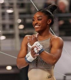 a female professional wrestler is smiling and holding her hands together