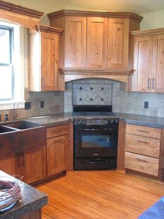 a kitchen with wooden cabinets and black appliances