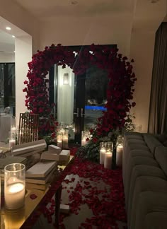 a living room filled with lots of furniture next to candles and flowers on the floor