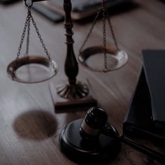 a judge's gaven and scale sitting on top of a wooden table