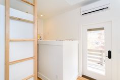 an empty room with white walls and wood floors