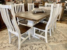 a dining room table with six chairs and a plate on the center piece in front of it