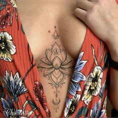 a woman with a flower tattoo on her upper arm and chest, wearing a red dress