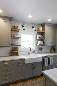 a kitchen with gray cabinets and white counter tops