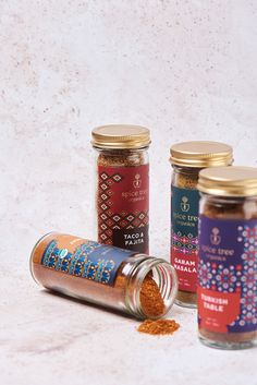 three jars filled with spices sitting next to each other