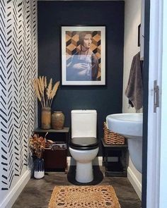 a bathroom with a toilet, sink and pictures on the wall