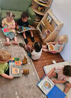 several children are sitting on the floor reading books