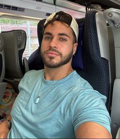 a man sitting in the back seat of a bus wearing a bandana on his head