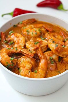 a white bowl filled with shrimp and sauce