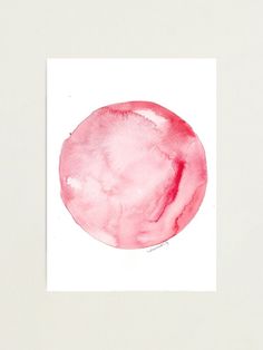 a pink circle painted in watercolor on white paper