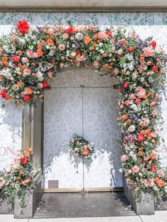 an entrance decorated with flowers and greenery