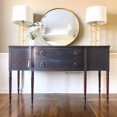 a dresser with two lamps and a mirror on it