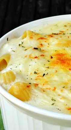 a white bowl filled with macaroni and cheese on top of a green cloth