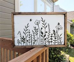 a wooden sign with flowers painted on it