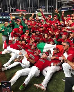 the baseball team is posing for a group photo with their trophy in front of them