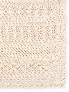 a crocheted blanket with white yarn on the bottom, and an intricate design