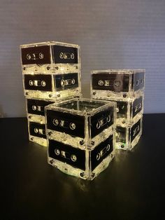 four stacked cassettes sitting on top of a black table next to eachother