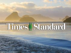 the words times standard are in front of an image of two people standing on the beach