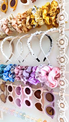 there are many pairs of sunglasses hanging on the wall next to each other with flowers in them