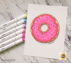 a pink frosted donut with sprinkles on it next to markers