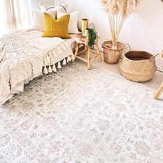 a bedroom with a bed, rug and baskets on the floor