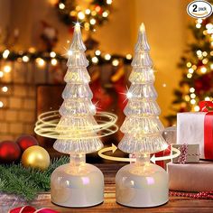 Add a touch of sparkle to your holiday decor with this set of two Rotating Mercury Glass Christmas Trees. These elegant tabletop decorations feature twinkling LED fairy lights that rotate, creating a cozy and magical atmosphere. Made from high-quality glass, each tree is adorned with glitter and built-in LED lights that shimmer like stars. Battery-operated with a convenient timer function, these trees are perfect for flexible placement without the hassle of tangled wires. Ideal for Christmas, Thanksgiving, birthdays, or any festive occasion, these trees will delight your friends and family. Each tree measures approximately 3.54 inches in diameter and 11.81 inches in height, making them a perfect centerpiece for your table or mantelpiece

 #GlassChristmasTree #MercuryGlass #ChristmasDecor # 2 Christmas Trees, Christmas Centrepiece Table, Battery Operated Lamps, Glass Trees, Sparkling Christmas