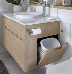 a bathroom with a sink, mirror and toilet paper dispenser in it