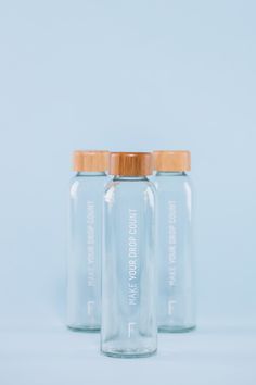 three glass jars with wooden lids on a blue background