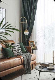 a living room with leather couches and green drapes on the windowsills