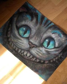 a painting of a cat's face with blue eyes