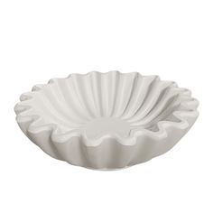 a white bowl that is sitting on a white tablecloth and it's shaped like a flower