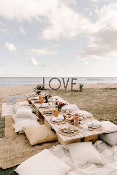 a picnic table set up on the beach with love sign