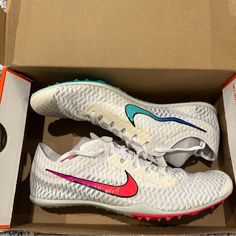 a pair of white nike shoes in a box