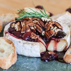 a piece of bread topped with jelly and pecans sitting on top of a table