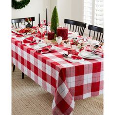 a red and white checkered table cloth on a dining room table set for christmas