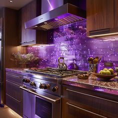 a kitchen with purple lighting and stainless steel stove top, oven hood, and cabinets