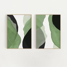 two green and black paintings hanging on the wall