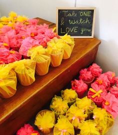 there are many cupcakes that have been decorated with yellow and pink flowers on them