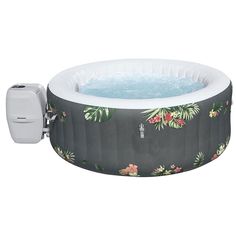 an inflatable hot tub with flowers and palm leaves on the side, next to a