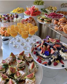 an assortment of desserts and drinks are on display at a buffet table with wine glasses