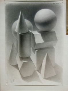 a drawing of some shapes on a piece of paper next to a ball and cube