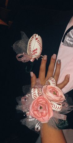 a woman's hand with flowers and baseballs on it