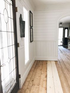 an empty room with wood floors and white walls